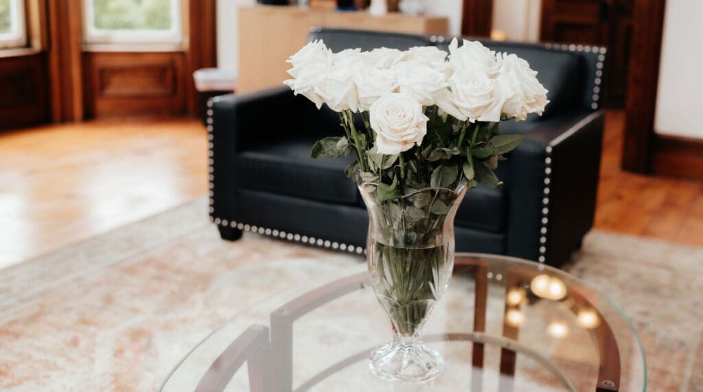 skaneateles white roses in vase in lobby